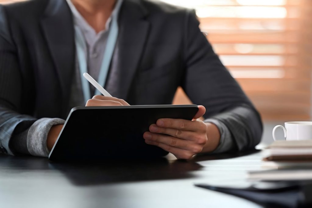 A man taking notes on an iPad