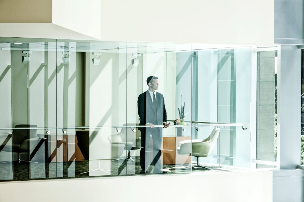 Businessman Looking out of a Skyscraper Window